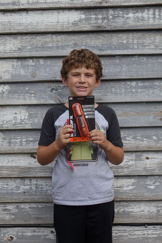 A young bushcrafter holding new gear at a past Gathering